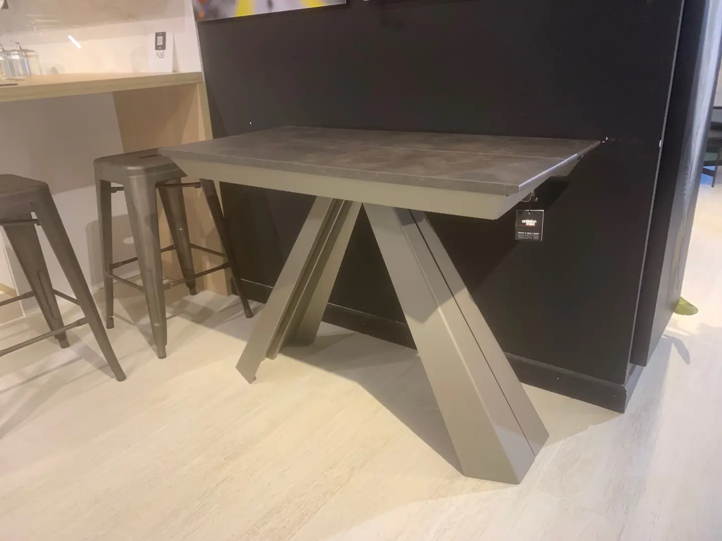 Consolle allungabile Convivium di Cattelan Italia con piano effetto pietra antracite e gambe in metallo verniciato, esposta nello showroom Arredamenti Soldi a Follonica