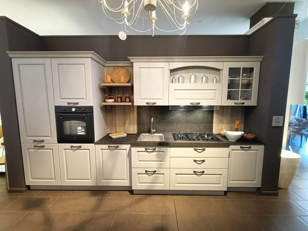 Cucina Asolo di Arredo3, composizione lineare con ante a telaio laccate color panna, top in gres antracite e colonna forno, esposta nello showroom Arredamenti Soldi